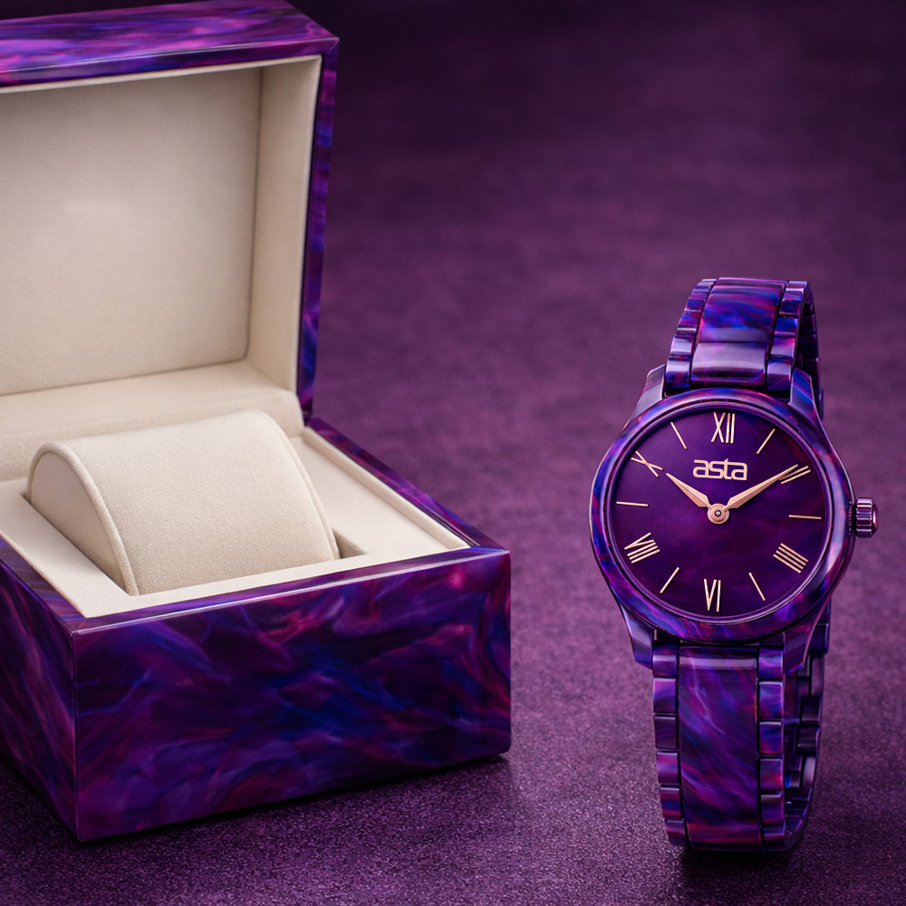 Elegant dark purple marbled asta acetate wristwatch standing beside its matching open watch storage case